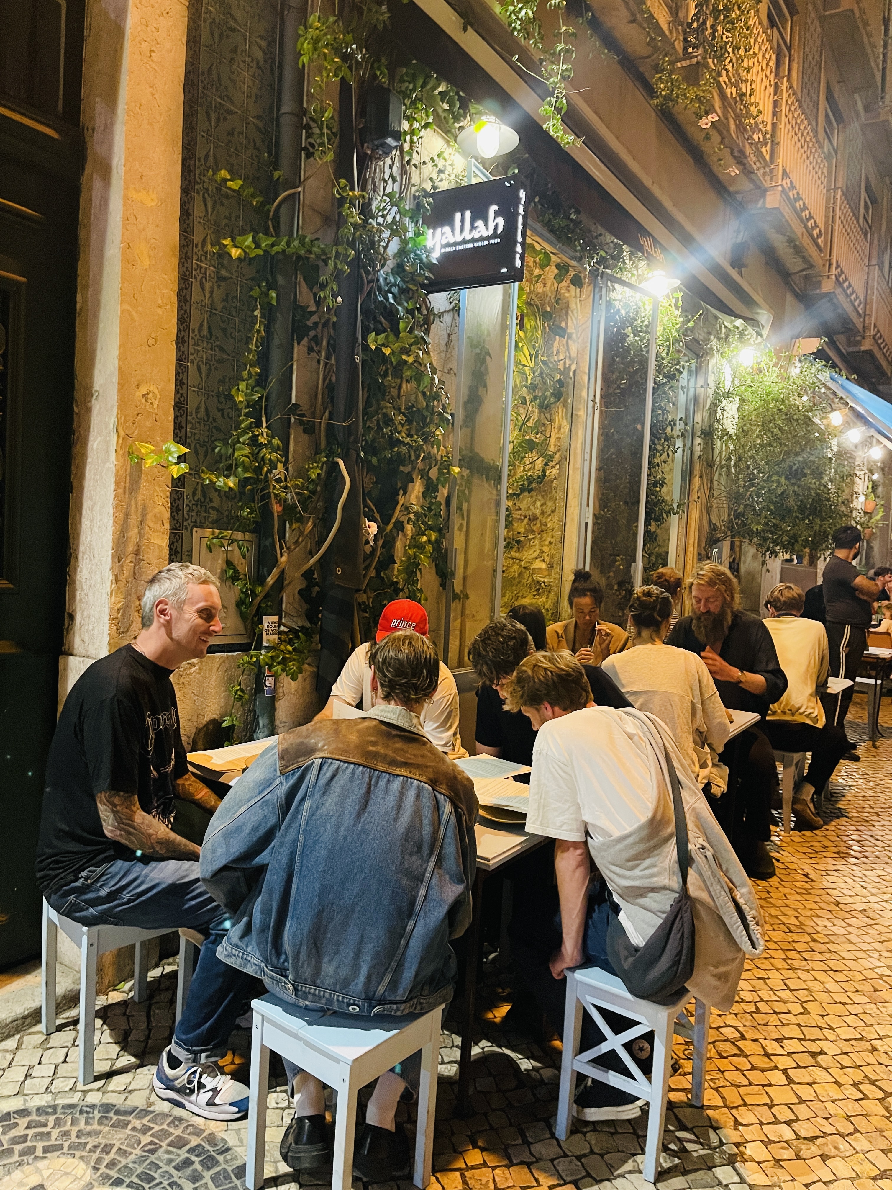 Friends dining on Yallah’s terrace at night
